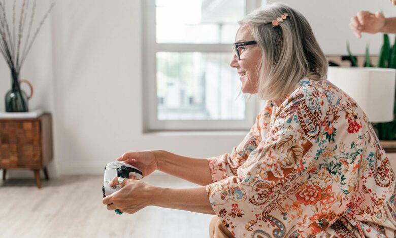 Elderly woman enjoying a video game session indoors, showcasing active lifestyle.