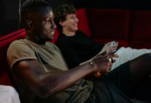 Two friends enjoying a video game session together indoors with controllers.