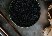 Close-up of black caviar in a tin, showcased with a rustic culinary aesthetic.