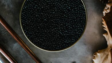 Close-up of black caviar in a tin, showcased with a rustic culinary aesthetic.
