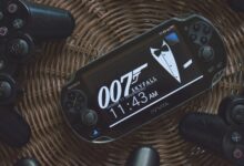 PS Vita showing 007 theme surrounded by PlayStation controllers on a wicker basket.
