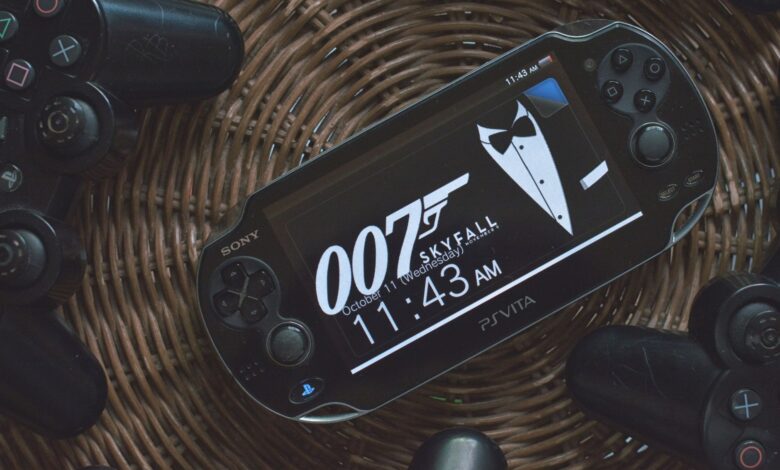 PS Vita showing 007 theme surrounded by PlayStation controllers on a wicker basket.
