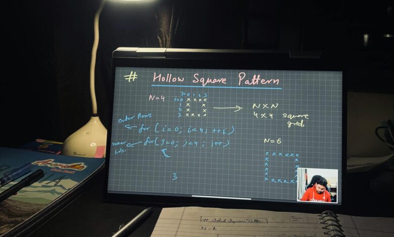 A dimly lit home study setup with laptop displaying coding notes on a hollow square pattern.