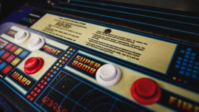 Close-up of a vintage arcade game control panel with colorful buttons and instructions.