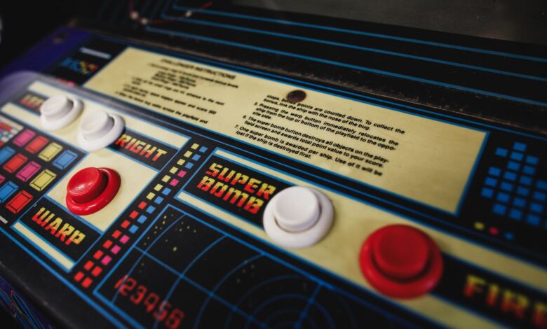 Close-up of a vintage arcade game control panel with colorful buttons and instructions.