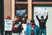 A group of people at a political rally in Wheeling, West Virginia, supporting different 2020 election campaigns.