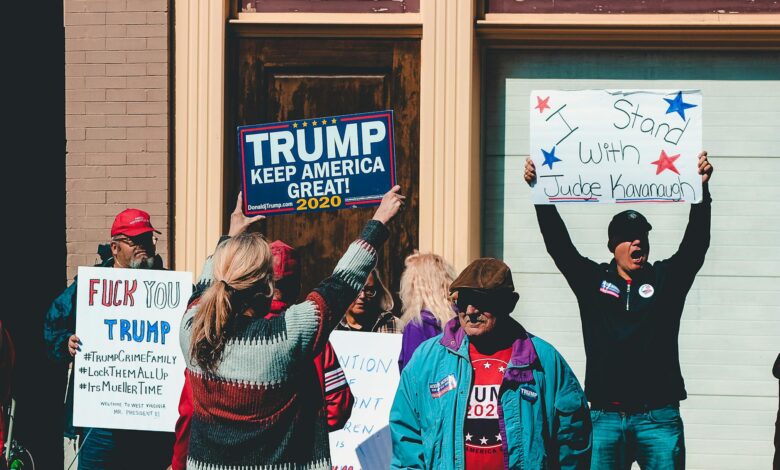 A group of people at a political rally in Wheeling, West Virginia, supporting different 2020 election campaigns.