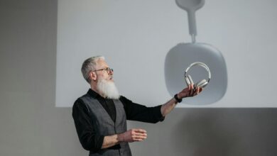 Mature man presenting wireless headphones in a business setting.