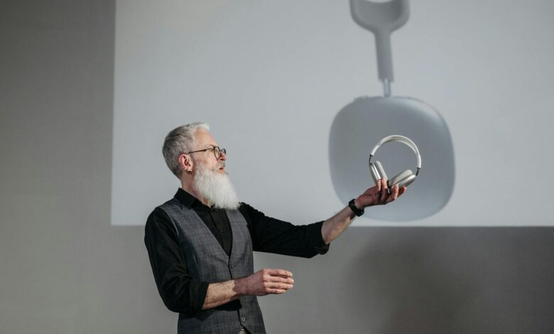 Mature man presenting wireless headphones in a business setting.