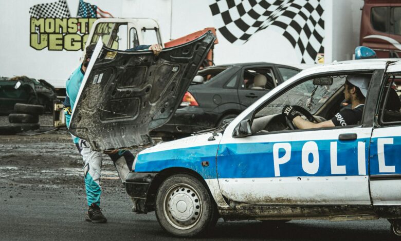 Stunt performers managing a police car scene at a thrilling event.