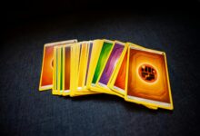 From above of colorful pack of trading cards for game placed on gray surface