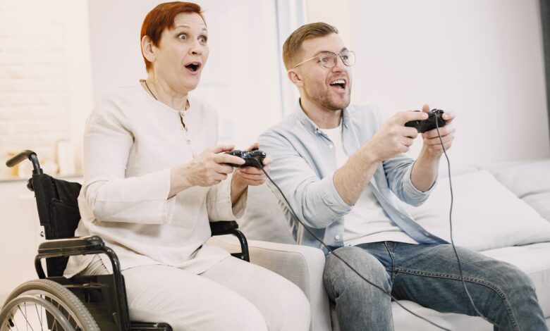 A joyful scene of an adult man and senior woman playing video games indoors, embracing technology and fun.