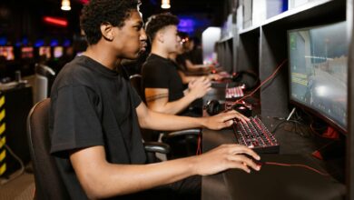 Group of young adults deeply engaged in competitive online gaming at a cyber cafe.