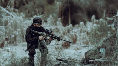 Man in tactical gear practicing outdoor training in Miami's wild forested area, focused and prepared.