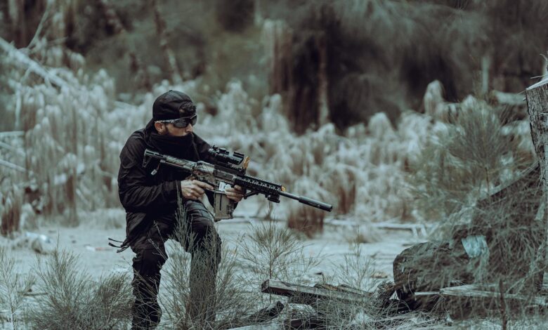 Man in tactical gear practicing outdoor training in Miami's wild forested area, focused and prepared.