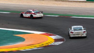 Two race cars navigate a sharp turn on a professional track, capturing the essence of motorsport speed.