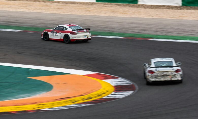 Two race cars navigate a sharp turn on a professional track, capturing the essence of motorsport speed.