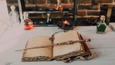 Magical close-up of a wand on an ancient spell book with potions.