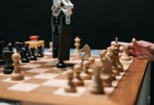 Close-up of a robotic arm playing chess against a human, showcasing AI technology in a classic board game setting.