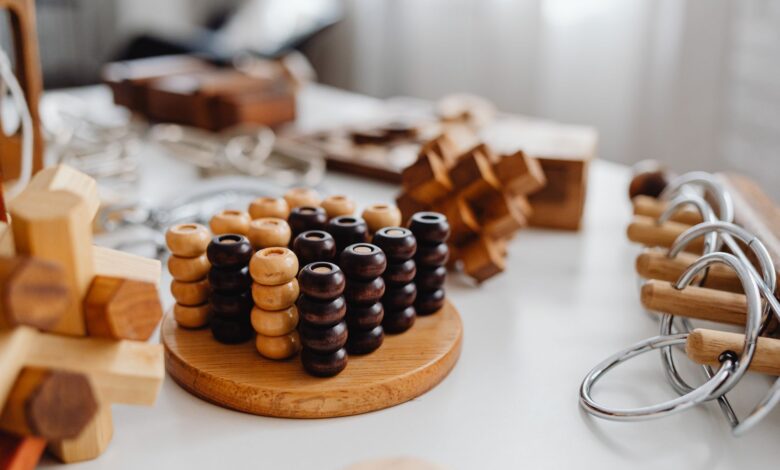 Close-up of various wooden brain teaser puzzles arranged on a table indoors.