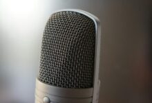 Detailed view of a professional condenser microphone with a blurred backdrop, ideal for audio equipment themes.