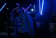 Friends at a movie theater enjoying a night out with popcorn and 3D glasses.