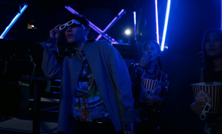 Friends at a movie theater enjoying a night out with popcorn and 3D glasses.