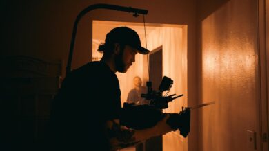 Cinematographer using advanced camera rig indoors with warm lighting.
