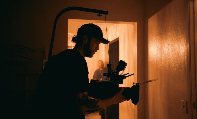 Cinematographer using advanced camera rig indoors with warm lighting.