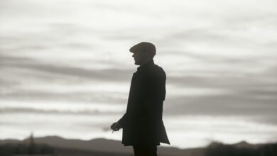 Silhouette of a man in a hat standing against a dramatic cloudy sky, conveying mystery and solitude.