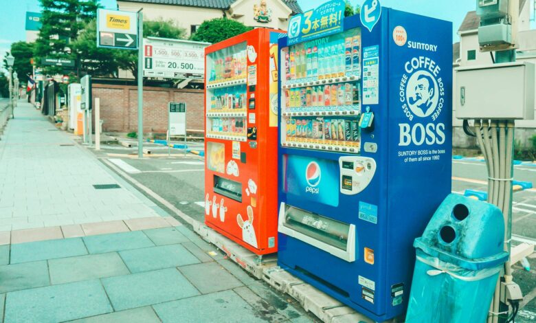 Colorful vending machines offering snacks and drinks on a street in Kobe, Japan.