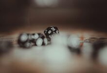Artistic photo of multi-sided gaming dice in a blurred setting, highlighting the number 20.