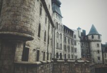 A medieval stone castle exterior with turrets and windows, creating a historic and mysterious atmosphere.