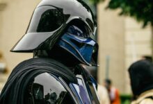 Detailed side view of a cosplayer dressed as Darth Vader at an event.