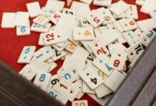 A collection of numbered game tiles scattered on a red surface, perfect for game night themes.