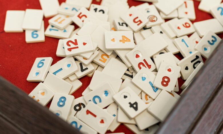 A collection of numbered game tiles scattered on a red surface, perfect for game night themes.