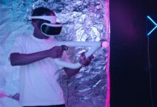 Man playing an immersive virtual reality game with VR goggles and controller.