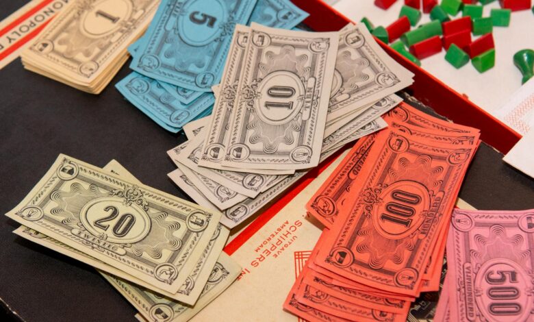 Colorful Monopoly money and game pieces arranged on a game board for a classic board game night.