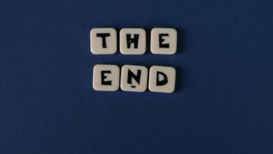 Scrabble tiles spelling 'The End' on a minimalist blue background. Perfect for conceptual designs.