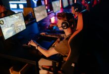 A group of gamers focused on a competitive match in a dimly lit esports arena.