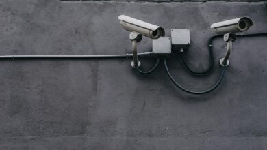 Two surveillance cameras mounted on a concrete wall, highlighting security technology.