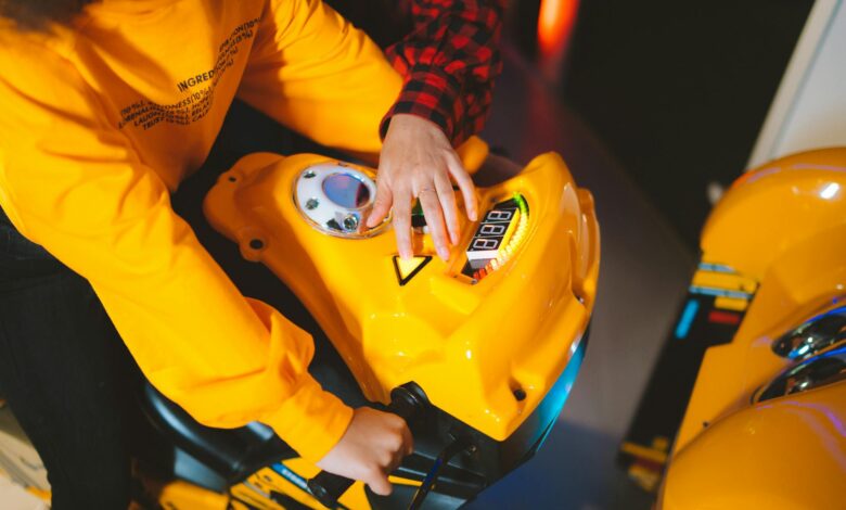 Close-up of children playing together on an arcade racing simulator, enjoying a fun gaming experience.