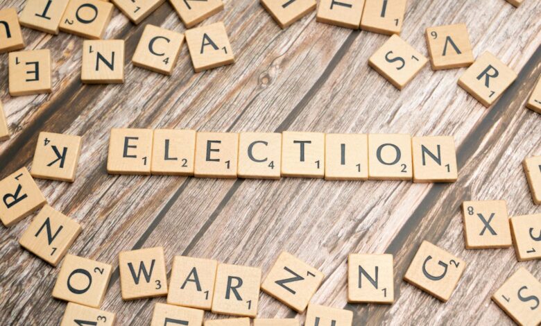 Wooden letter tiles form the word 'election' on a textured wooden surface, symbolizing voting.
