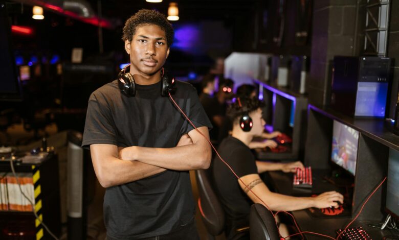 Young gamer standing with arms crossed in an esports arena, exuding confidence.