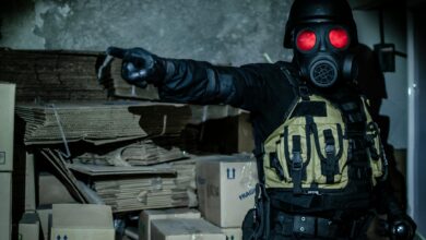 Dark and moody scene of a person in tactical gear and gas mask in an abandoned warehouse.