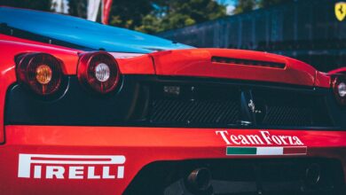 Racing car with Pirelli branding, featuring aerodynamic rear designs. Captured in daylight outdoors.