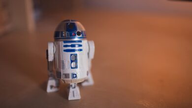 Detailed shot of R2-D2 toy figure on a warm-toned wooden surface.
