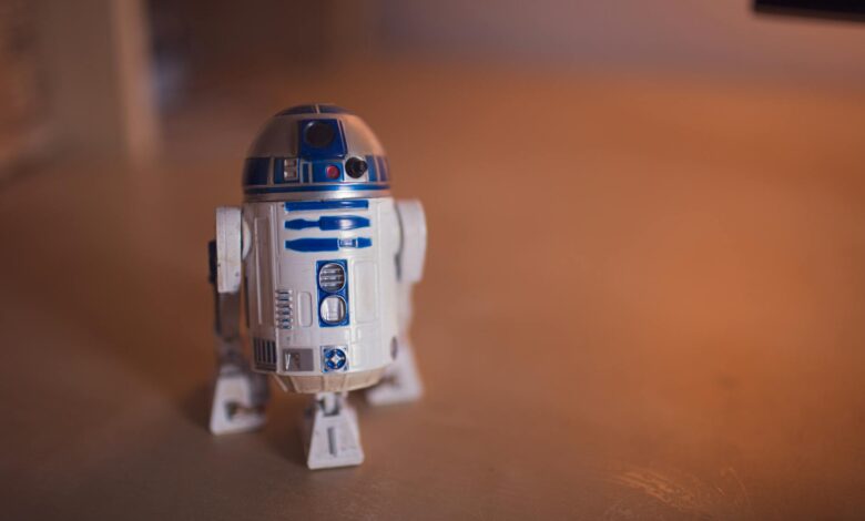 Detailed shot of R2-D2 toy figure on a warm-toned wooden surface.