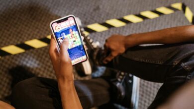 A person playing a colorful puzzle game on a smartphone while seated indoors.
