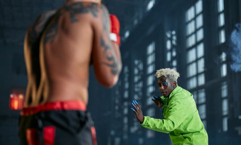 Intense indoor cosplay martial arts duel between two men in vibrant outfits.